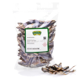 Eine durchsichtige Plastiktüte, gefüllt mit getrocknetem Fisch, mit der Aufschrift "Masterfeed Premium Große Sprotten," die Nährwertinformationen und Zusammensetzungsdetails anzeigt.