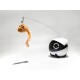 Ein robotisches Spielzeug, das einer Katze ähnelt, mit einem weißen und schwarzen Körper, mit einer baumelnden orangefarbenen Maus mit einem flauschigen Schwanz, entworfen für das Spielen mit Haustieren.