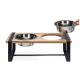 Eine stilvolle erhöhte Futterstation für Haustiere aus Holz und Metall, mit zwei Edelstahlschüsseln, von denen eine angehoben wird.