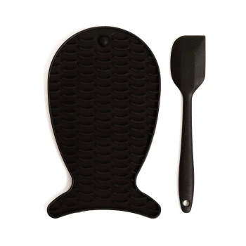Schwarze Silikon-Hundematte in Fischform, kombiniert mit einem passenden schwarzen Spatel, beide für eine einfache Reinigung konzipiert.