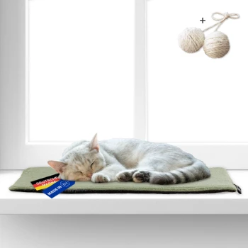 Schlafende weiße Katze auf einer grünen Matte am Fenster, mit den Etiketten „Deutsche Marke“ und „Made in EU“ sowie zwei Seilbällen darüber.