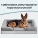 Deutscher Schäferhund liegt entspannt auf grauem Bett mit Rand; Text: „Komfortabler, atmungsaktiver Noppenschaumstoff“