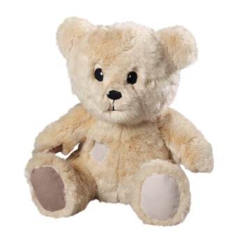 Ein weicher, beiger Plüsch-Teddybär mit schwarzen Augen und einer gestickten Nase, mit hellen Flecken an seinen Pfoten und dem Bauch.