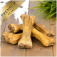 Premium Hundekauknocken, die auf einer Holzoberfläche gestapelt sind, mit einem dekorativen grünen Gras-Hintergrund.