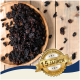 Getrocknete schwarze Früchte in einer Holzschüssel auf einer Holzoberfläche, mit einem Aufkleber, der 'Beste Qualität' und '10 Jahre' auf Deutsch angibt.
