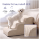 Kleiner weißer Hund auf beige gerippten Haustiertreppen am Bett; deutscher Text ‚Stabiler Schaumstoff-Halt‘ mit Icons.