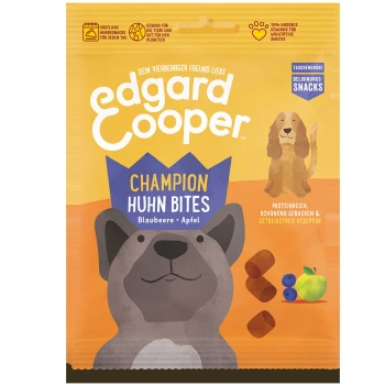 Edgard Cooper Champion Huhn Bites Hundeleckerlis Verpackung mit einer Cartoon-Hund, Heidelbeeren und Apfelillustrationen, mit Text auf Deutsch.