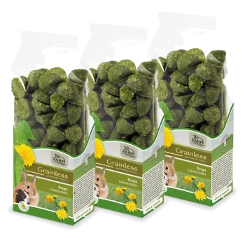 Drei transparente Beutel mit JR Farm grainless Löwenzahn Drops für Haustiere, mit grünen, ovalen Leckerlis und Bildern eines Kaninchens und eines Meerschweinchens.