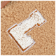 Gros plan sur une couverture pour animaux douce et beige, avec une lettre 'C' brodée en blanc, entourée de marron, mettant en valeur sa texture en peluche.