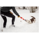 Eine Person in einer schwarzen Daunenjacke und Handschuhen spielt im tiefen Schnee Tauziehen mit einem weiß-braunen Hund.