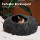 Gemütliches graues Haustierbett mit runder Form und kleinem Eingang, auf einer weißen Decke mit grünen Pflanzen. Text: "Perfekter Rückzugsort."