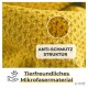Nahaufnahme von weichem, gelbem Mikrofaserstoff mit dem Text "ANTI-SCHMUZT STRUKTUR", der auf das schmutzabweisende, haustierfreundliche Material hinweist.
