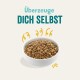 Schüssel mit Haustierfutter, gefüllt mit trockenem Futter, mit dem Text "Überzeuge DICH SELBST" darüber in fetter, verspielter Schrift.