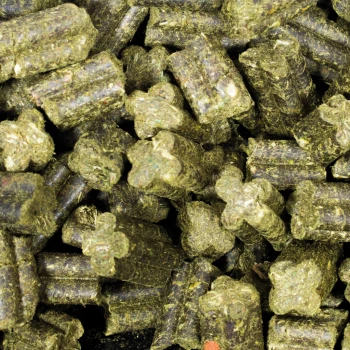 Gros plan sur des granulés de nourriture pour animaux verts en forme d'étoile, présentant un mélange de formes cylindriques et étoilées, idéales pour les petits animaux.