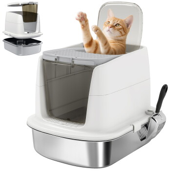 Geschlossene weiße Katzentoilette mit durchsichtiger Schwingtür, Edelstahlboden und Schaufel; orangegetigerte Katze greift darin nach oben.