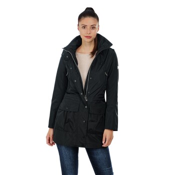 Eine Frau trägt eine stilvolle schwarze wasserdichte Jacke mit Kapuze, kombiniert mit einem leichten Pullover und Jeans, und steht selbstbewusst.