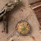 Eine Schüssel mit buntem Haustiervogel-Futter, gefüllt mit Samen, Körnern und getrockneten Früchten, umgeben von verstreuten Samen auf einem Jutesack-Hintergrund.