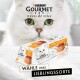Zbliżenie białego kota z zielonymi oczami obok opakowania musu Purina Gourmet Revelations, które mówi "WÄHLE IHRE LIEBLINGSORTE."