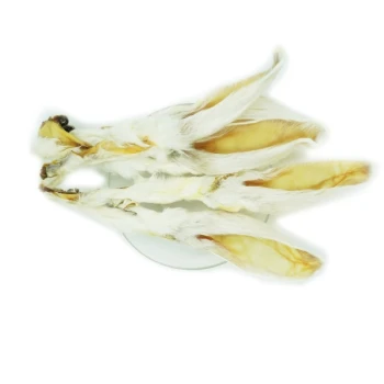 Drei getrocknete Kaninchenohren auf einem weißen Teller angeordnet, die ihr Fell und ihre Textur zeigen, ideal für Haustierleckereien.