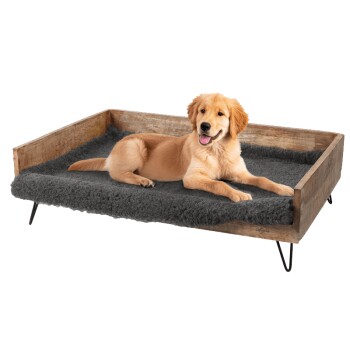 Golden Retriever Welpe liegt auf einem grauen, mit Fleece ausgekleideten Holzhaustierbett mit Metallbeinen, aus einem Online-Tiergeschäft.