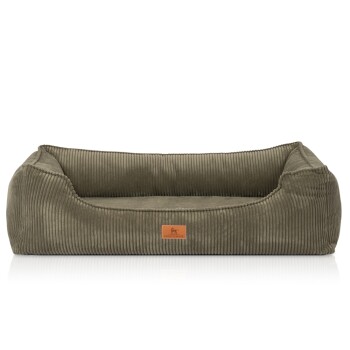 Olivegrünes Cord-Hundebett mit Randpolstern, niedriger Vorderseite und braunem Lederanhänger mit Hundesilhouette und kleinem Text.