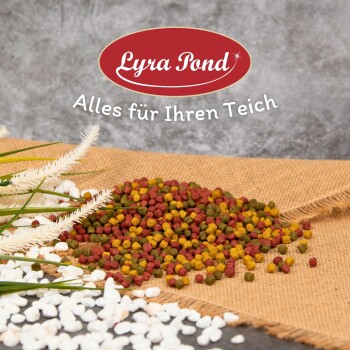 Bunte Fischfutterpellets, die auf Jute verstreut sind, mit grünem Gras und weißen Steinen, mit dem Text "Lyra Pond - Alles für Ihren Teich."