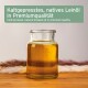 Glas mit Leinöl auf Holztisch; Text 'Kaltgepresstes, natives Leinöl' und englische Aufschrift 'Cold-pressed, natural linseed oil'.