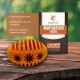 Orangenes, rugbyförmiges Hundefutter aus 100% Naturkautschuk, mit Verpackung, die als "RUGBYSNACKER RAYA" gekennzeichnet ist und wichtige Merkmale auflistet.