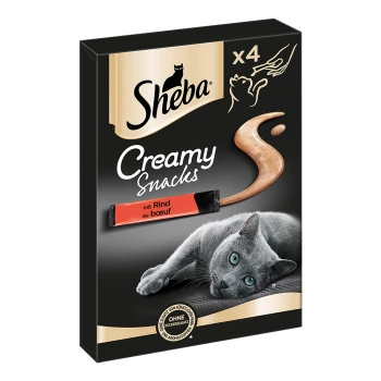 Emballage de Sheba Creamy Snacks présentant un chat gris allongé, avec un tourbillon de collation crémeuse et le texte 'mit Rind au boeuf' sur le devant.
