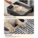 Katzenstreu-Kiste mit herausnehmbarem Einsatz und Gitterdesign, zeigt eine Hand, die Streu schöpft, und Katzenpfoten auf dem Gitter.