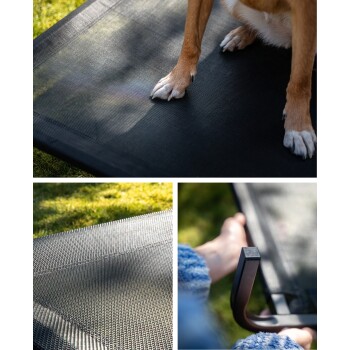 Eine Nahaufnahme eines Hundes, der auf einer schwarzen Haustiermatte ruht, mit Fokus auf seinen Pfoten. Die Matte ist strukturiert und auf grünem Gras platziert.