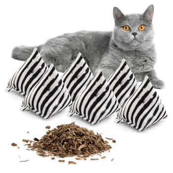 Eine graue Katze mit leuchtend orangefarbenen Augen liegt neben fünf gestreiften Katzenminzkissen und einem Haufen getrockneter Katzenminze.