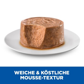 Eine runde, feuchte Tierfuttermousse auf einem weißen Teller, mit dem Text "WEICHE & KÖSTLICHE MOUSSE-TEXTUR" in fettem Blau darunter.