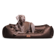 Ein entspannter Hund liegt auf einem plüschigen, braunen Haustierbett mit einem gesteppten Design und einem Lederetikett, das "tierlindo" liest.