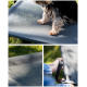 Ein kleiner Hund sitzt auf einem grauen erhöhten Haustierbett, mit Nahaufnahmen der strukturierten Oberfläche des Bettes und einer Hand, die seinen Metallrahmen hält.
