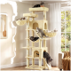 Beiger hoher Kratzbaum mit Plattformen, Hängematten und Höhle, mit sechs Katzen in einem sonnenbeschienenen Wohnzimmer am Fenster.