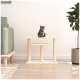 Ein verspieltes getigertes Kätzchen sitzt auf einem beigen Katzenbaum mit zwei Plattformen, positioniert in einem gemütlichen Wohnzimmer neben einem grünen Sofa und einer Topfpflanze.