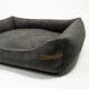 Grau Haustierbett mit einer plüschigen Oberfläche und erhöhten Rändern, mit einem kleinen Lederetikett, das "Rex Production" geprägt hat.