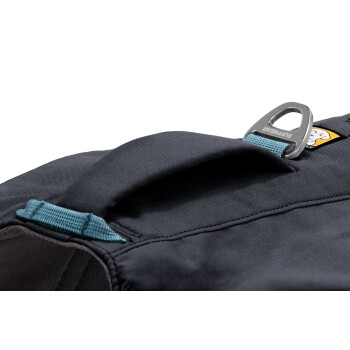 Nahaufnahme einer schwarzen Haustiertrage mit einem blauen Griff und einem Metallbefestigungspunkt, mit einem sichtbaren gelben und weißen Logo.