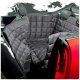Ein gepolsterter Autositzbezug für Haustiere in einem schwarzen, gesteppten Design, der eng auf dem Rücksitz eines Autos sitzt, mit einer sichtbaren roten Tür.
