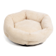Ein weiches, rundes Haustierbett in cremigem Beige mit einer strukturierten Oberfläche und plüschigen Seiten, ideal für kleine Hunde oder Katzen.