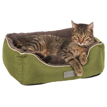 Eine entspannte getigerte Katze, die in einem grünen Haustierbett mit weichem grauen Innenraum liegt, mit einem kleinen Etikett, das "KERBL" liest.