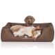 Ein entspannter Hund liegt auf einem plüschigen braunen Hundebett mit einem Logo, das "KNUFFELWUFF" liest, und zeigt Komfort und Stil.