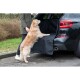 Złoty retriever wchodzi do tyłu czarnego SUV-a, wspierany przez osobę w zielonej kurtce. Widoczna jest czarna mata do transportu zwierząt.