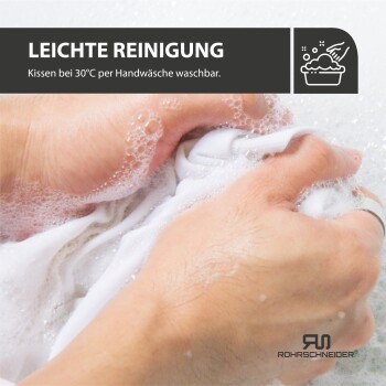 Hände waschen ein weißes Kissen von Hand in seifigem Wasser; Text lautet „Leichte Reinigung, Kissen bei 30°C per Handwäsche waschbar.“