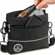 Eine Hand, die ein Hundeleckerli in eine schwarze Hundeleckerli-Tasche mit Reißverschluss und einem Logo steckt, mit einem Schultergurt und reflektierenden Details.