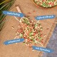 Bunte Haustierfutterpellets, die um eine Holzschaufel verstreut sind, beschriftet mit "mehrfarbig", "nährstoffreich", "schwimmt" und "mit Spirulina."