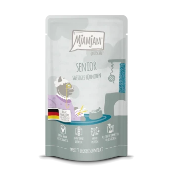 Beutel mit Mjamjam Senior-Katzenfutter mit einer Cartoon-Katze in einem lila Kleid, beschriftet mit "Senior" und "Saftiges Hühnchen," hochprozentigen Fleisch- und getreidefreien Symbolen.
