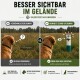 Golden Retriever Welpe beißt auf ein grün-weißes Canvas-Hundespielzeug im Gras im Freien.