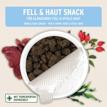 Geöffnete Dose eines braunen Haut-&-Fell-Haustiersnacks mit rohem Fleisch und Hagebutten; Etikett: 'FELL & HAUT SNACK'.